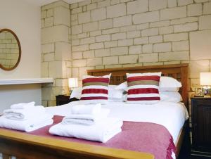 Un dormitorio con una cama con toallas. en Lady Jane Grey, en Winchcombe
