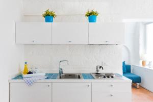 Una cocina con gabinetes blancos y un fregadero. en Dimora Talenti Guest House, en Polignano a Mare