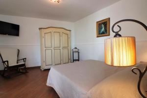 1 dormitorio con 1 cama con lámpara y silla en Estate4home - MAISON LIRIO en Positano