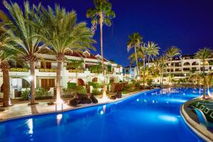 a resort pool with palm trees and a building at Parque Santiago III Official in Playa de las Americas