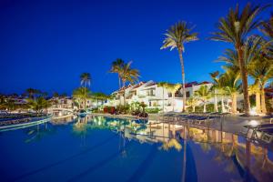 a resort swimming pool with palm trees and houses at Parque Santiago III Official in Playa de las Americas