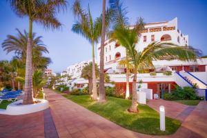 a resort with palm trees in front of a building at Parque Santiago III Official in Playa de las Americas