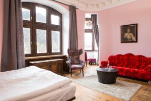 ein Schlafzimmer mit einem Bett und einem roten Sofa in der Unterkunft Hotel Villa Vie Cochem in Cochem