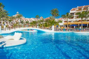 a pool at a resort with a boat in the water at Parque Santiago III Official in Playa de las Americas +37 photos