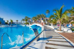 a swimming pool at a resort with palm trees at Parque Santiago III Official in Playa de las Americas