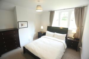 a bedroom with a white bed and a window at Entire Victorian Lodge in a privately gated estate with secure parking for two cars and a newly refurbished bathroom in Bath