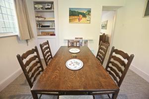 een houten tafel in een eetkamer met stoelen bij Entire Victorian Lodge in a privately gated estate with secure parking for two cars and a newly refurbished bathroom in Bath