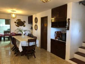 uma cozinha e sala de jantar com mesa e cadeiras em Shekinah House em Cumbuco