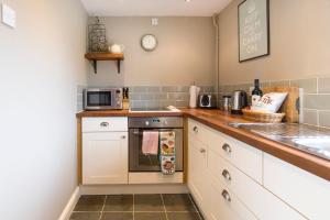 a kitchen with a sink and a stove top oven at Grooms Cottage in Weedon Bec