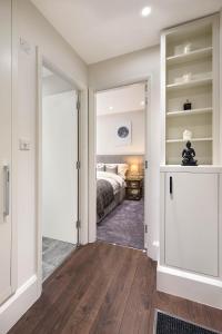 a bedroom with a bed and a door leading into a room at Beautiful Chelsea Apartment in Fashion District in London