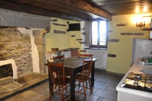 a kitchen with a table and chairs in a room at Il Borgo Di Monica in Domodossola
