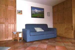 a living room with a blue couch and a table at Case Gran Paradiso Rhemes Notre Dame in Rhêmes-Notre-Dame