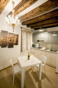 biały stół jadalny i krzesła w kuchni w obiekcie San Marco Luxury Studio w Wenecji
