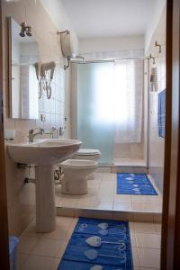 ein Bad mit einem Waschbecken, einem WC und einer Dusche in der Unterkunft B&B Le Magnolie in Amorosi