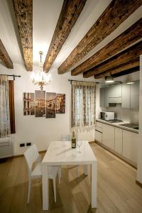 biała jadalnia z białym stołem i krzesłami w obiekcie San Marco Luxury Studio w Wenecji
