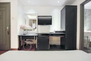 a black desk with a television in a room at A&EM - The Petit Hotel in Ho Chi Minh City