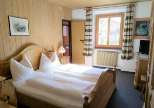 Schlafzimmer mit einem großen weißen Bett und einem Fenster in der Unterkunft Gasthof zur Sonne in Laas