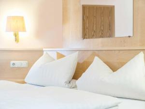 a bedroom with two white pillows and a mirror at Gästehaus Mönchshof in Sommerhausen