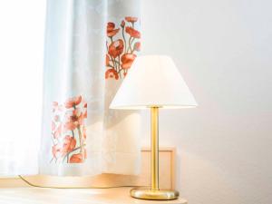 a lamp sitting on a table next to a curtain at Gästehaus Mönchshof in Sommerhausen