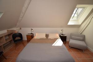 ein Schlafzimmer mit einem Bett, einem Stuhl und einem Fenster in der Unterkunft Le Moulin de Planiol in Le Vigan