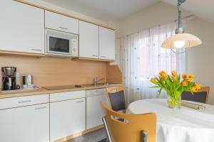eine Küche mit einem Tisch und einer Blumenvase darauf in der Unterkunft Haus Kleemann in Norderney