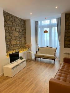 a living room with a couch and a television at OLA Apartamento - Perla Boutique Apartamentos in Donostia-San Sebastián