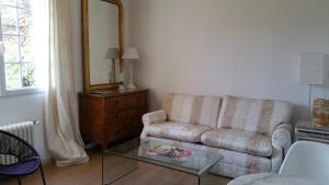 a living room with a couch and a glass table at Moulin du Hamelet in Saint-Aubin-sur-Scie