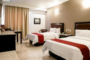 a hotel room with two beds and a desk at Imperio de Angeles Executive León by Real de Minas Business Class in León