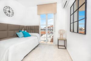 1 dormitorio con 1 cama y reloj en la pared en Myramar Premium Center, en Málaga