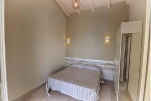 Habitación pequeña con cama y espejo. en Villetta La Vela by Agenzia SolturElba, en Capoliveri