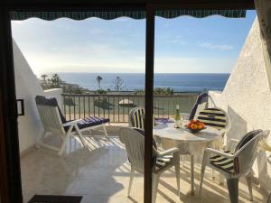 Un balcón con mesa y sillas y el mar. en Appartment Teneriffa Tamara Anlage, en Santiago del Teide