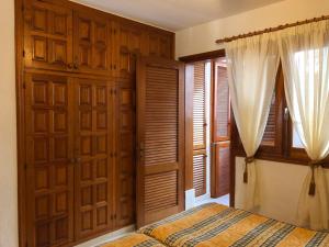 1 dormitorio con puertas de madera, cama y cortinas en Appartment Teneriffa Tamara Anlage, en Santiago del Teide 31 fotos más