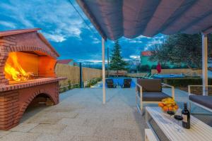eine Terrasse mit einem gemauerten Kamin und einem Stuhl in der Unterkunft HOLIDAY HOUSE LAVANDA in Gornji Zemunik