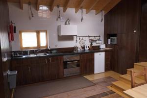 a kitchen with wooden cabinets and a sink and a window at Quinta dos Baldo in Freixo de Espada à Cinta
