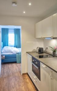 Zimmer mit einer Küche und einem Bett in einem Zimmer in der Unterkunft Airport & Messe Apartments in Hannover