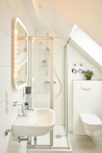 uma casa de banho branca com um lavatório e um WC em Airport & Messe Apartments em Hanôver