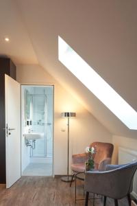 a skylight in a attic room with a sink and a chair at Airport & Messe Apartments in Hannover