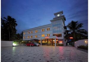 a building with a clock tower in a parking lot at Jk Park Residency Perambra in Mennānyam