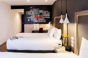 a hotel room with a white bed and white walls at Innside Lima Miraflores in Lima