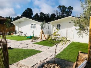 a garden with a white house and a lawn at Casas de Maderas Wooden Cabin in El Puerto de Santa María