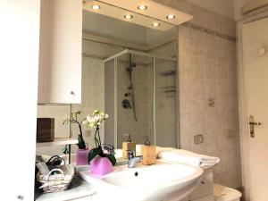 łazienka z umywalką i dużym lustrem w obiekcie Comfort House Pisa w Pizie +28 zdjęć