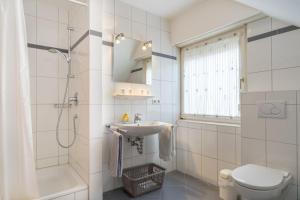 ein Badezimmer mit Waschbecken, Toilette und Dusche in der Unterkunft Haus Kleemann in Norderney