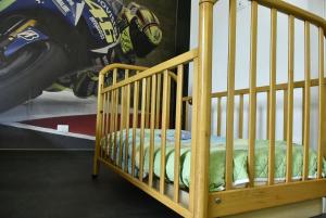 Rental rooms Antonella في تافوليا: سرير طفل في غرفة مع ملصق دراجة نارية