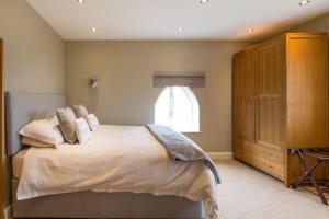 a bedroom with a large bed and a dresser at Grooms Cottage in Weedon Bec