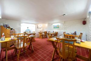 una sala da pranzo con tavoli e sedie in legno di Blue Swallow a Penrith