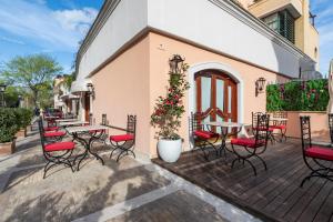 a patio with tables and chairs on a building at River Chateau Hotel in Rome