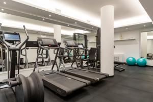 a gym with several treadmills and exercise bikes at River Chateau Hotel in Rome