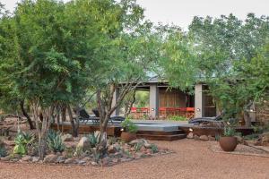 ein Haus mit Bäumen und Pflanzen davor in der Unterkunft Nyaleti Lodge in Hoedspruit