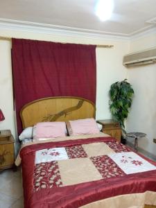 a bedroom with a bed with a red and white quilt at Your Dream Apartment in Agouza "FAMILY ONLY" in Cairo