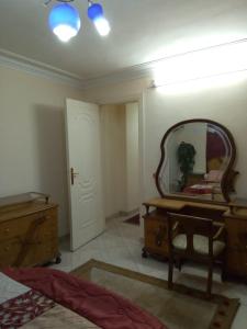 a bedroom with a mirror and a bed and a dresser at Your Dream Apartment in Agouza "FAMILY ONLY" in Cairo